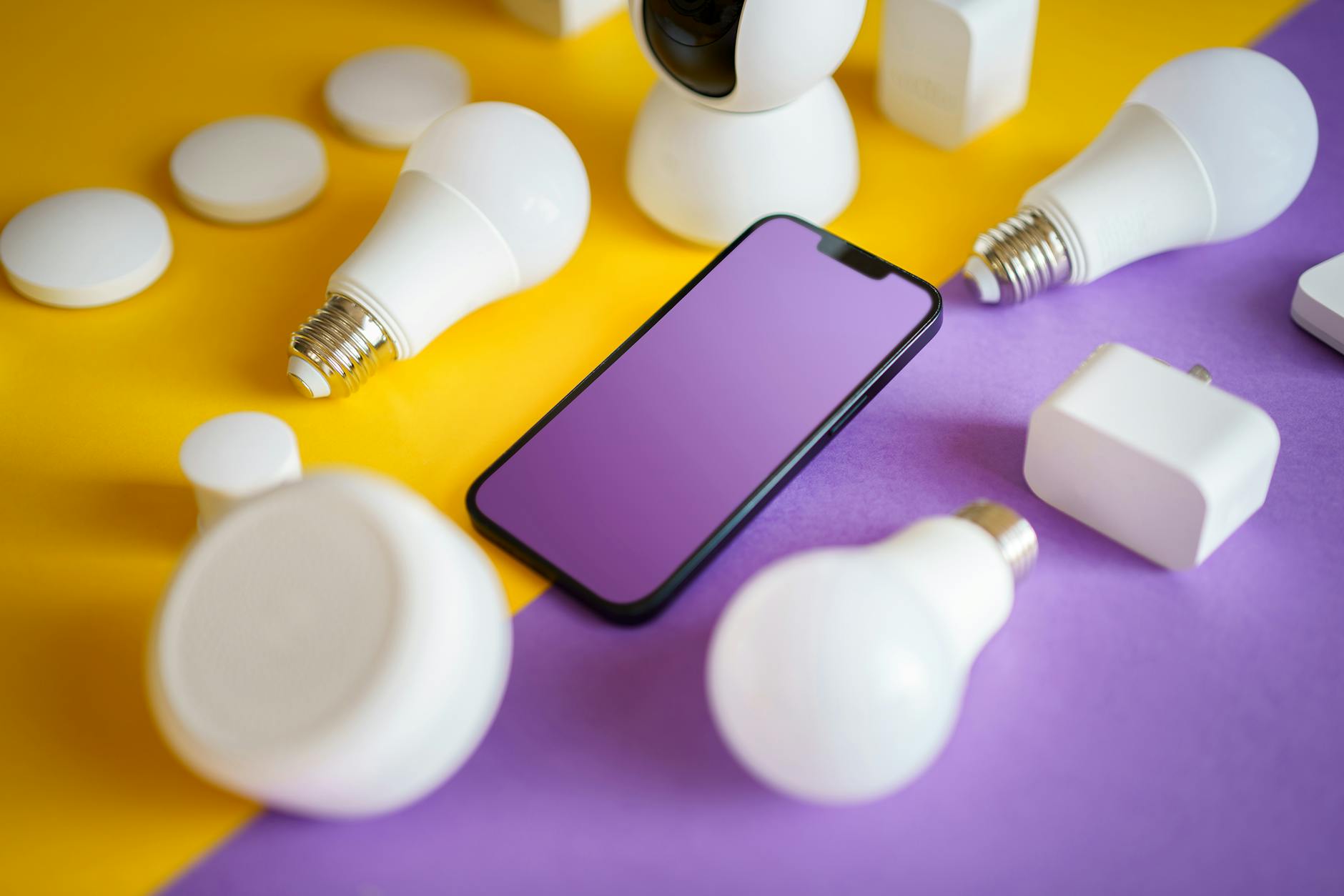 Systemy DALI i inteligentne sterowanie oświetleniem Biura, które naprawdę oszczędzają energię Kolorowe urządzenia smart home i smartfon na tle symbolizującym oszczędność ener
